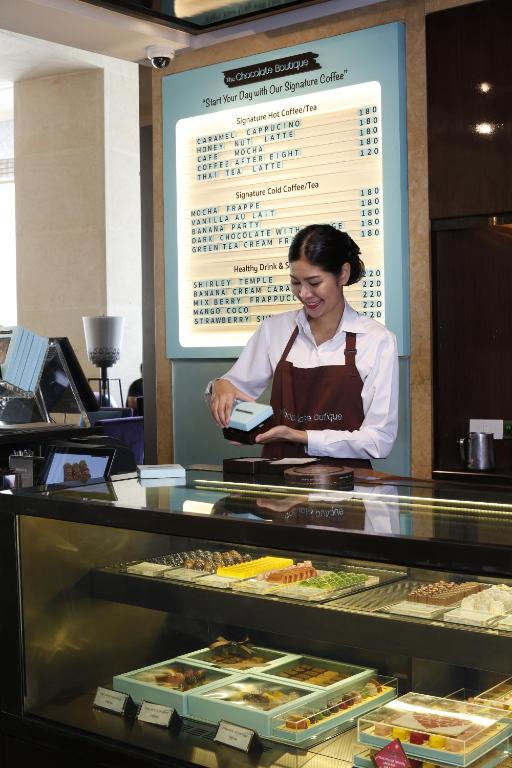 A bakery counter serves coffee and packaged pastries from a refrigerated display.