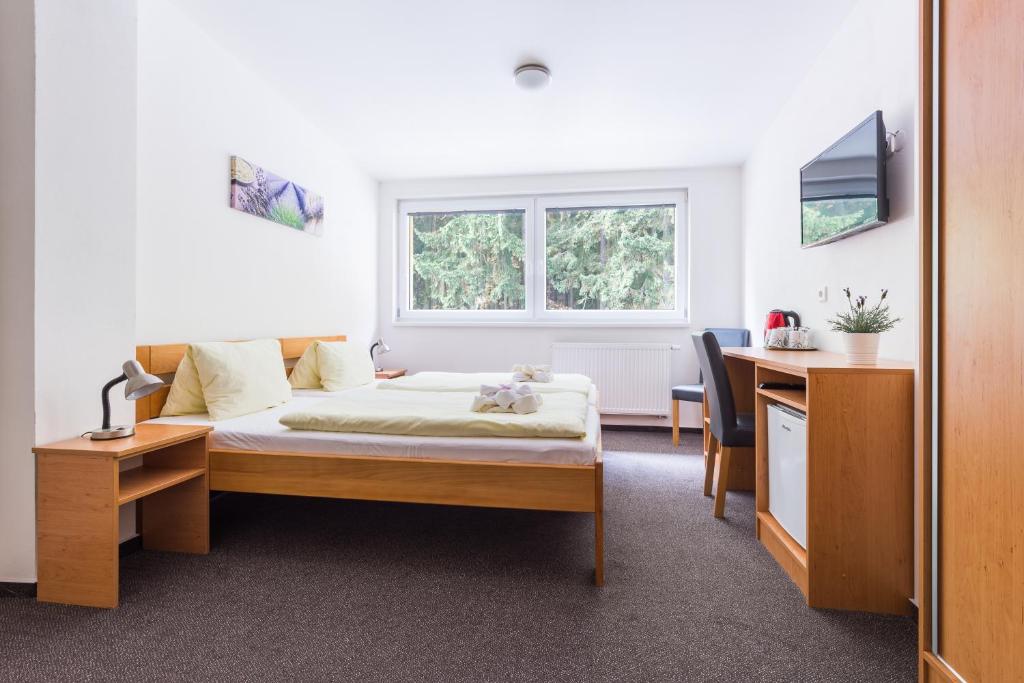 Postel nebo postele na pokoji v ubytování Hotel&Wellness Knížecí rybník