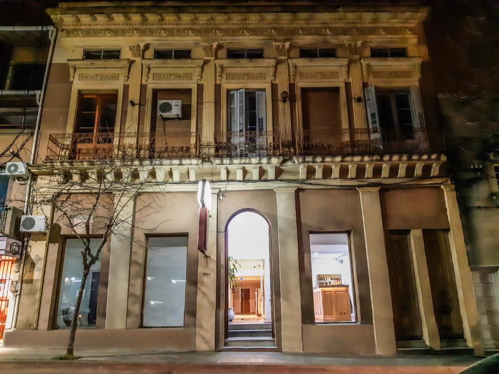 a building with an arch and a balcony at Hotel Tia in Salto