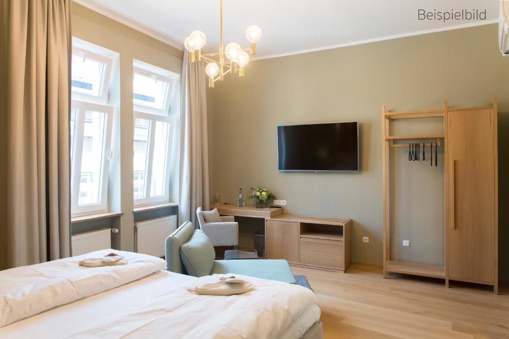 a hotel room with two beds and a flat screen tv at Cottage Rheingau Hotel in Walluf