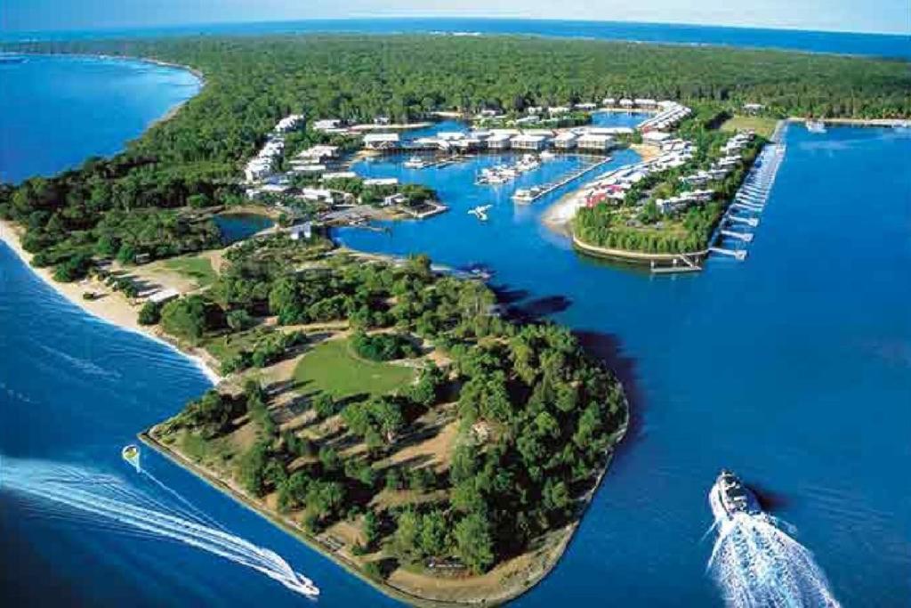 an island in the water with a boat in it at Charming Island Escape Gold Coast in South Stradbroke