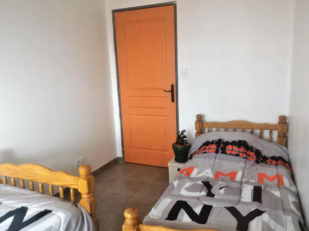 - une chambre avec un lit et une porte orange dans l'établissement l'île au Trésor : Chambre, à Le Monastier sur Gazeille