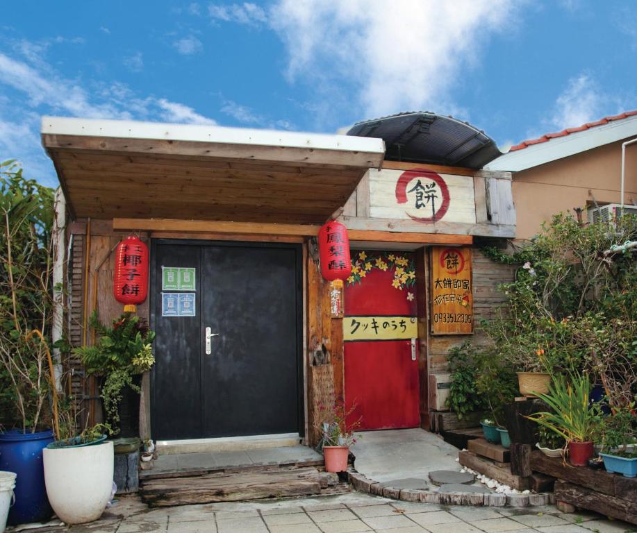 安平的住宿－台南大餅的家，一座房子,上面有红色的门和标志