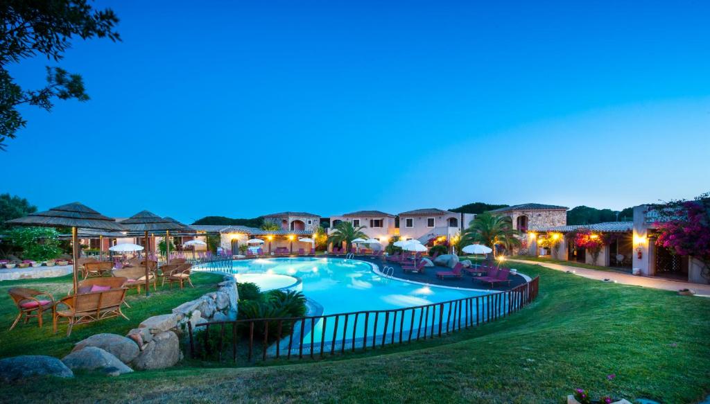 uma vista para uma piscina à noite em S'Incantu Resort em Villasimius