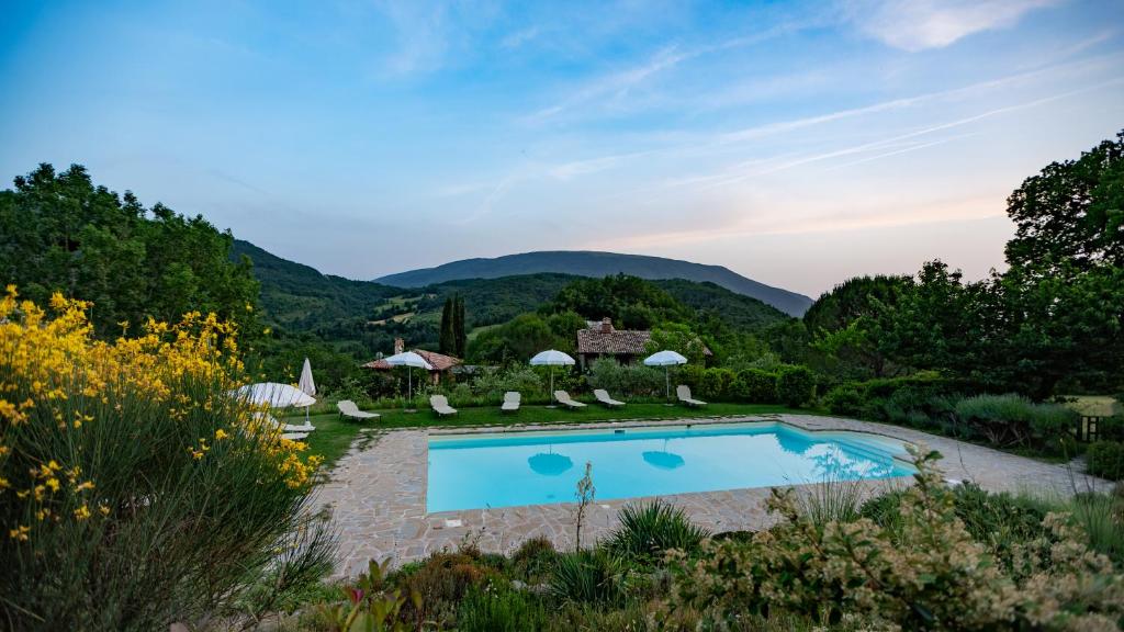 una piscina en un complejo con montañas en el fondo en Casa Rosa en Santa Maria Lignano