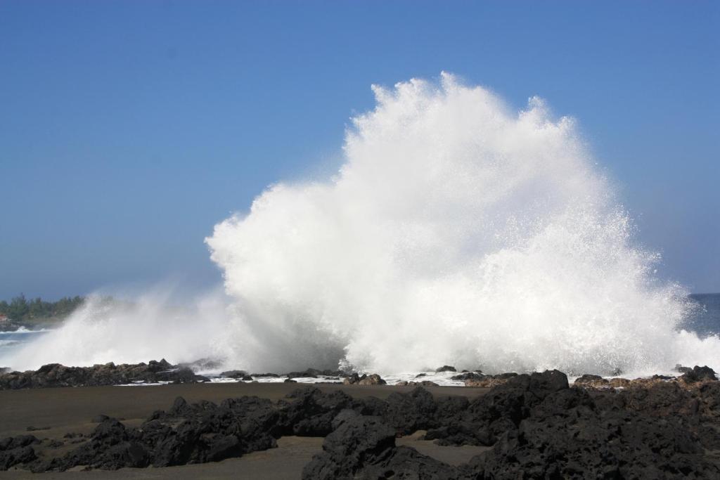 a large wave hitting the shore of a beach at Le Dodo Salé in Étang-Salé