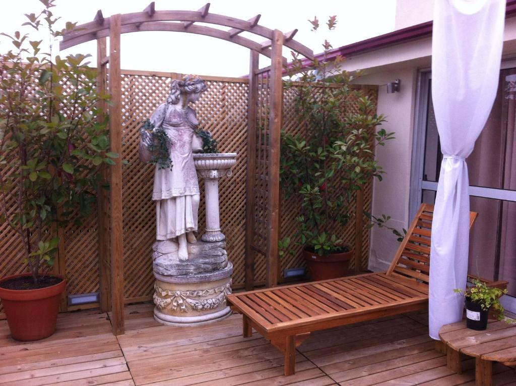 eine Statue einer Frau, die auf einem Deck sitzt in der Unterkunft Apartment Garden Music in Porto