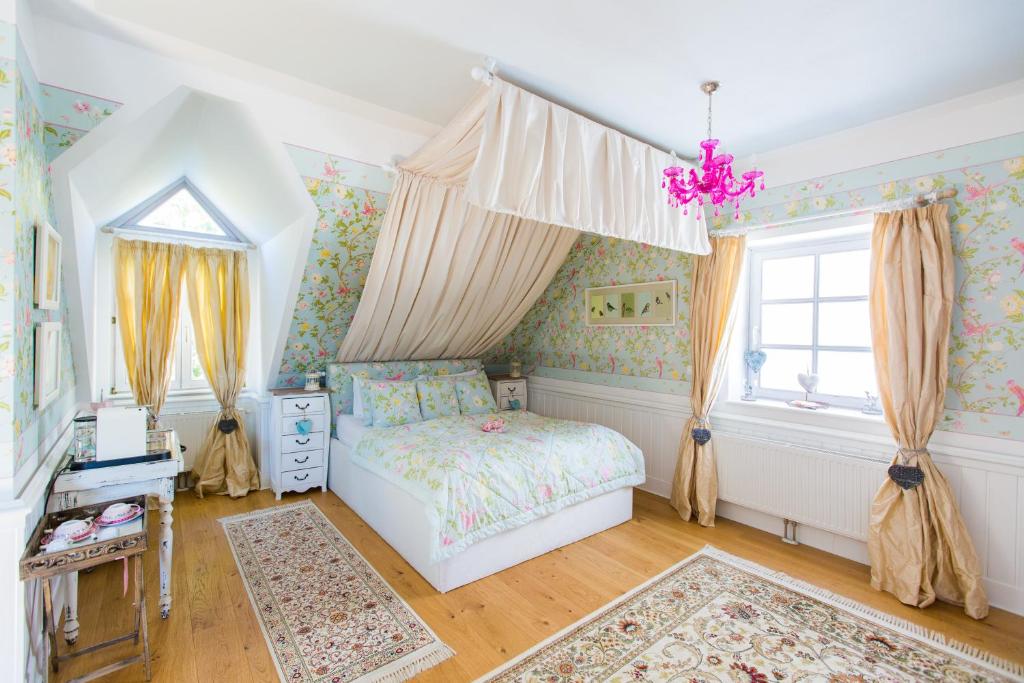 a bedroom with a bed and a window at OLEANDER SUITEN großzügig wohnen mit besonderem Charme in Trausdorf