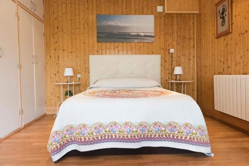 セネス・デ・ラ・ベガにあるRincón de Encarniの白いベッドと木製の壁が備わるベッドルーム1室が備わります。