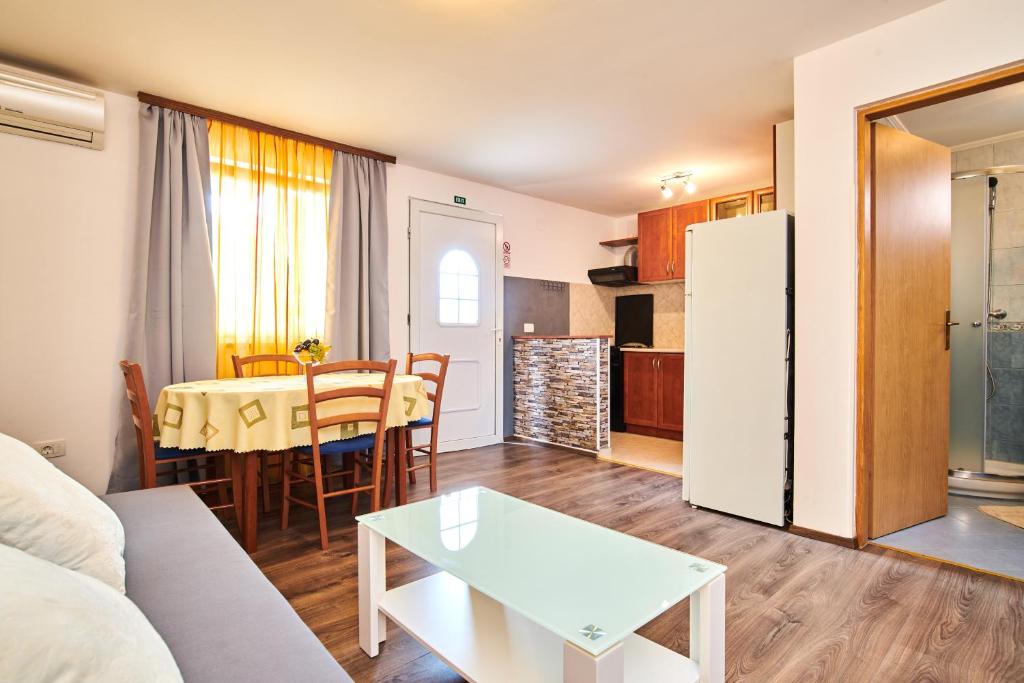 a living room and kitchen with a table and a refrigerator at APP Šverko in Vilanija