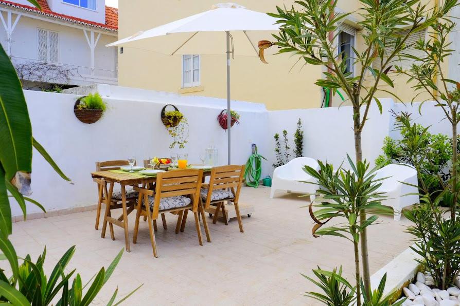 un patio con mesa, sillas y sombrilla en Lisbon Lights Apartments, en Lisboa