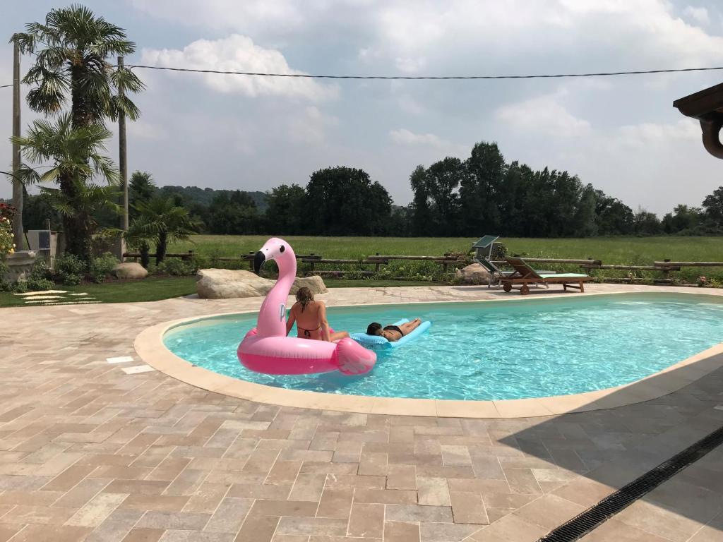 uma criança a montar um flamingo cor-de-rosa numa piscina em Valle Segreta em Valeggio sul Mincio