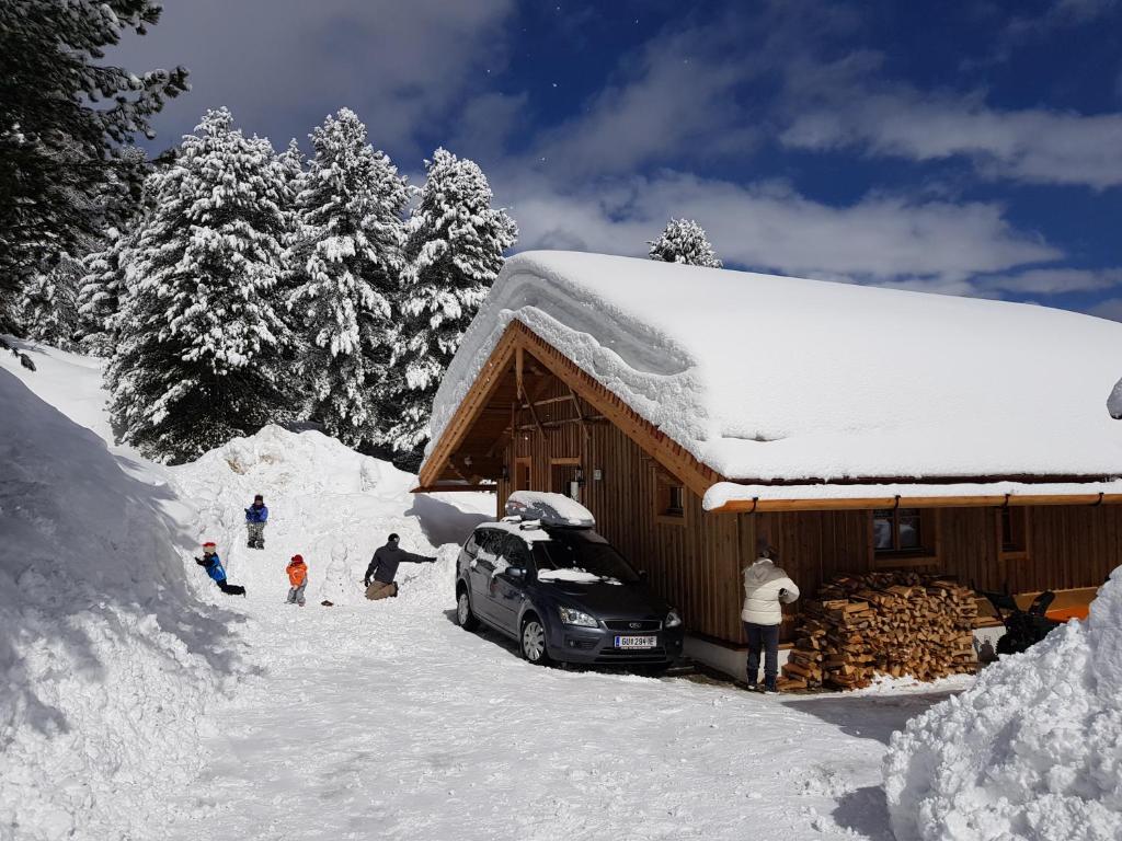 a group of people standing outside of a snow covered cabin at Wildererhütte Chalet Helmut in Turracher Hohe