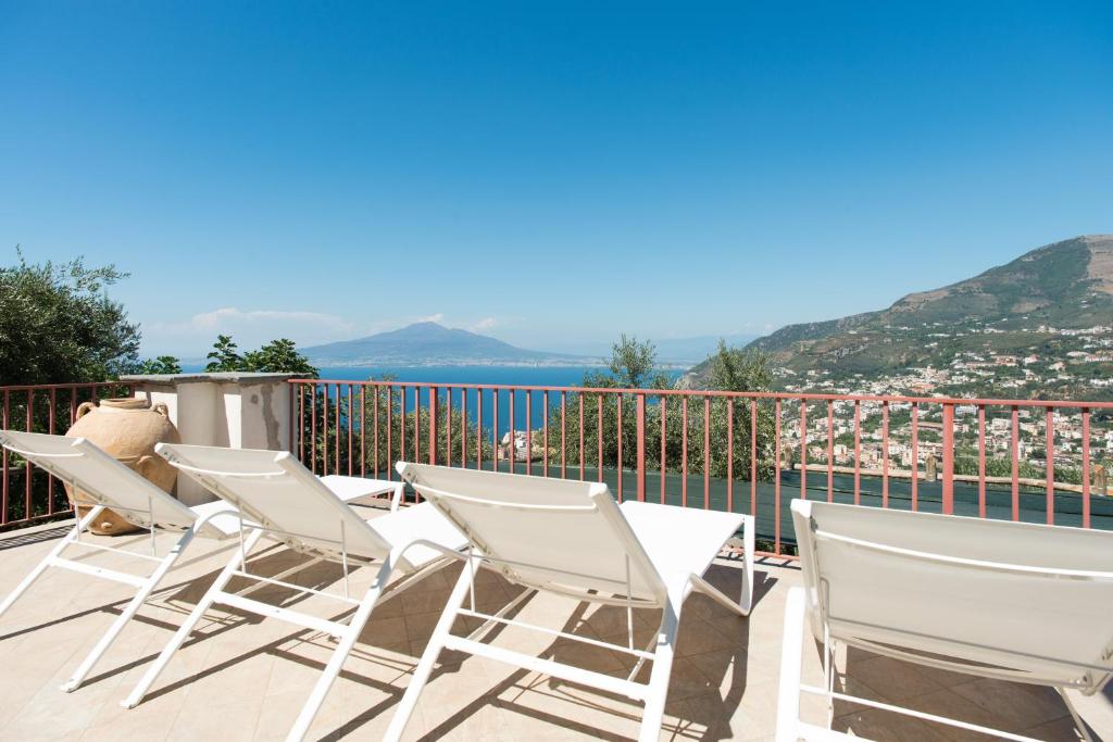 a group of chairs on a balcony with a view of the ocean at Villa Rosa di Nonna Rosa in Vico Equense