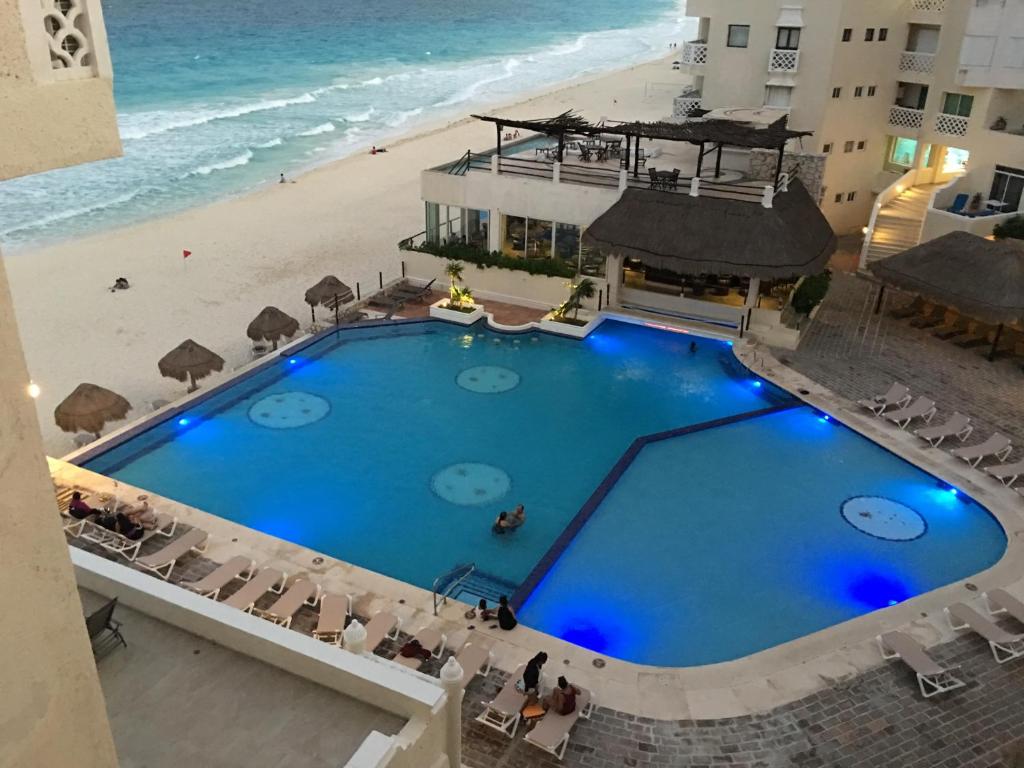 una vista aérea de una piscina junto a la playa en Cancun Plaza Condo Apartment, en Cancún