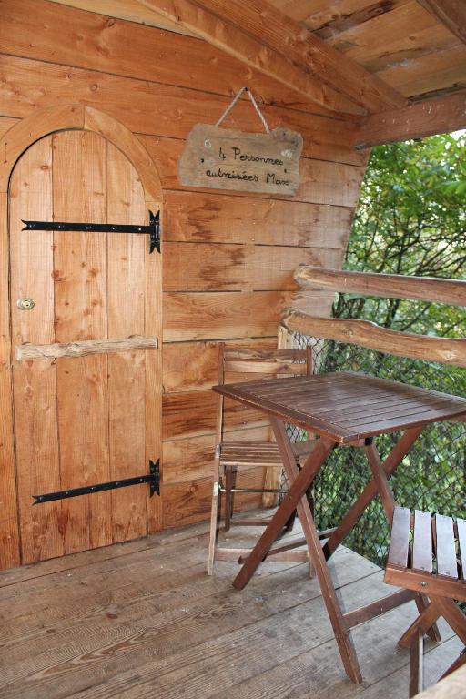 a wooden cabin with a table and a door at Les Ecolodges de l&#39;Orbière in Forcé