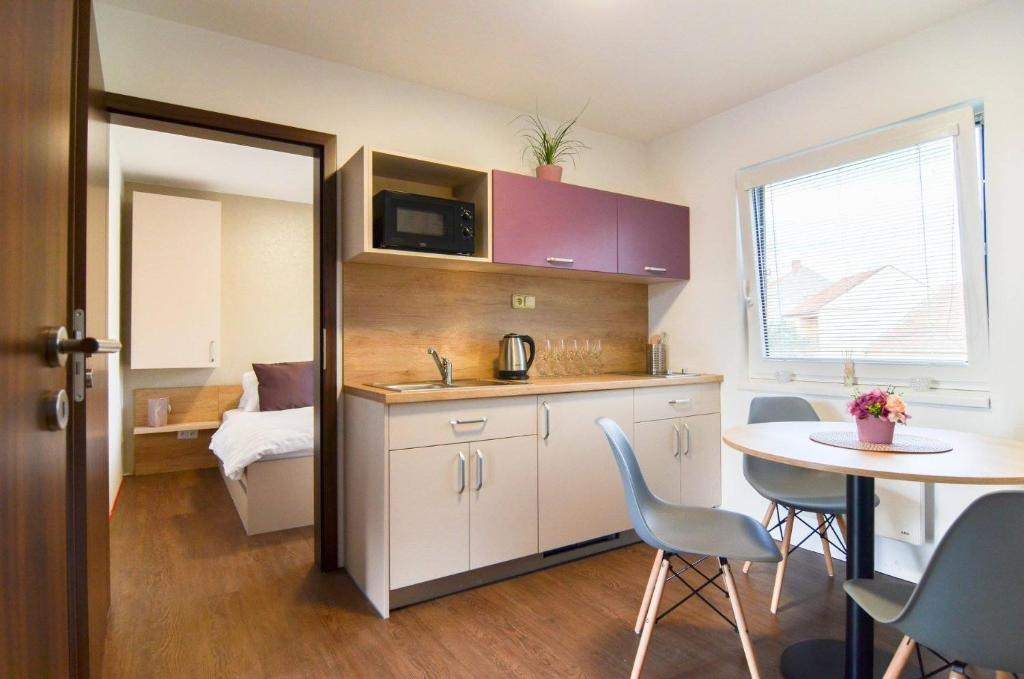 a small kitchen with a table and a dining room at Apartmány Milovice in Milovice