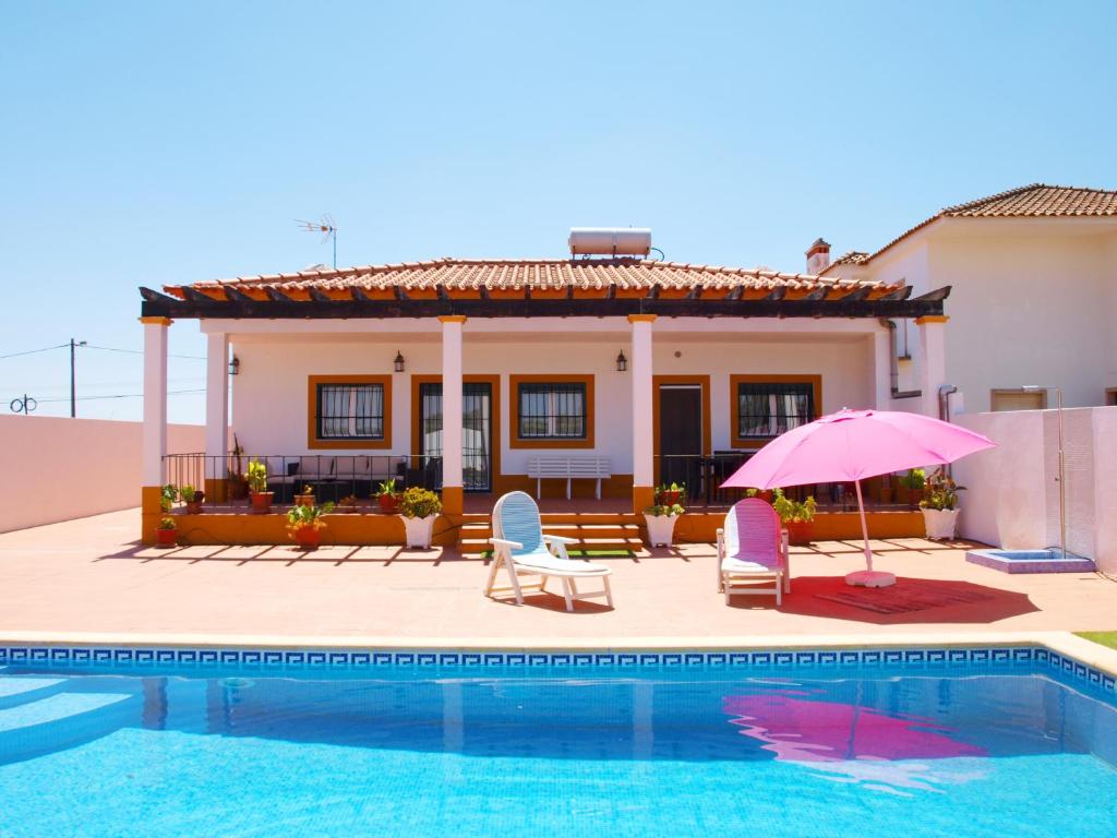 eine Villa mit einem Pool und einem Haus in der Unterkunft Chalé Chafaris D'el Rei in Elvas