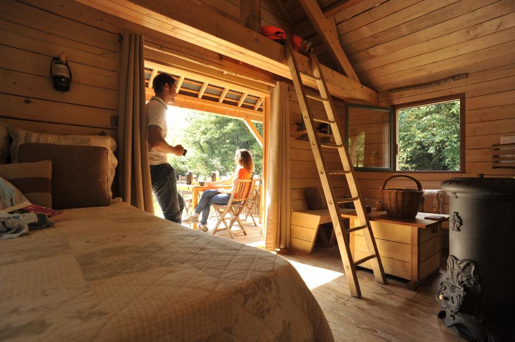 a man and a woman standing in a room with a ladder at Les Ecolodges de l&#39;Orbière in Forcé