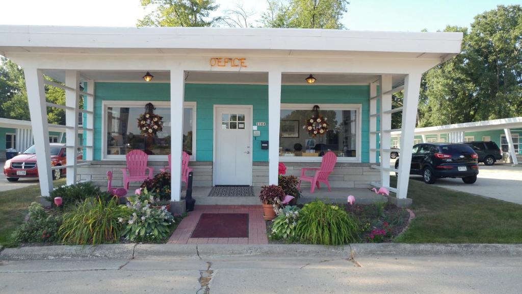 a coffee shop with pink chairs on the front porch at Motel 57 in Sturgeon Bay