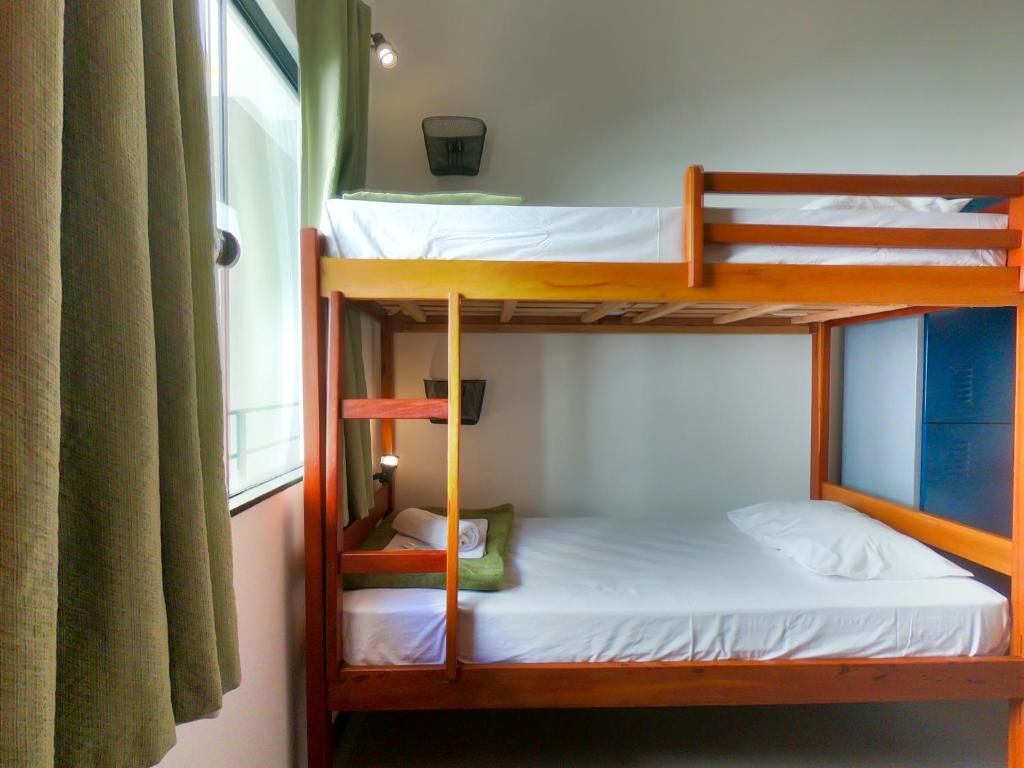 Dos literas en una habitación con ventana. en Guest House Cabo Frio, en Cabo Frío