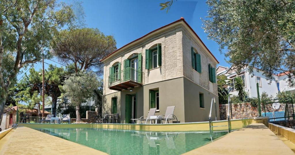 una casa con piscina al lado de un edificio en Ouzo Traditional House with private pool, en Plomari