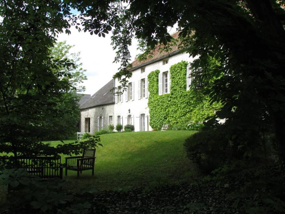 ein weißes Haus mit einer Bank im Gras in der Unterkunft Le Meix Gautheret in Merceuil