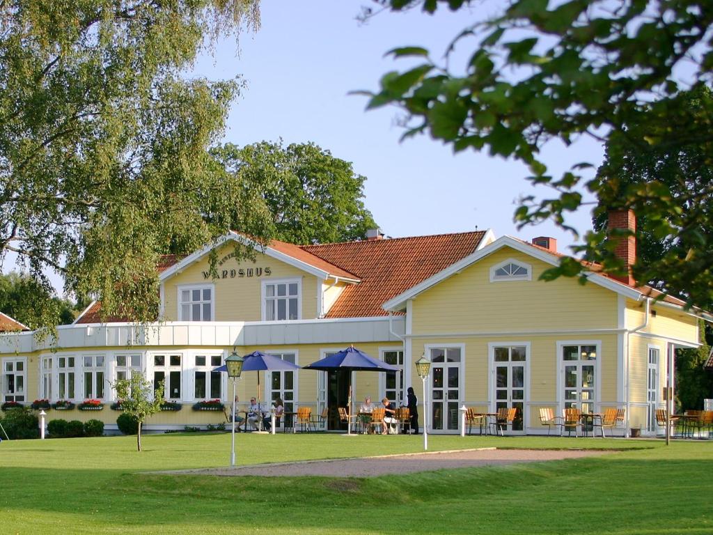 um grande edifício branco com mesas e cadeiras em Hestraviken Hotell & Restaurang em Hestra