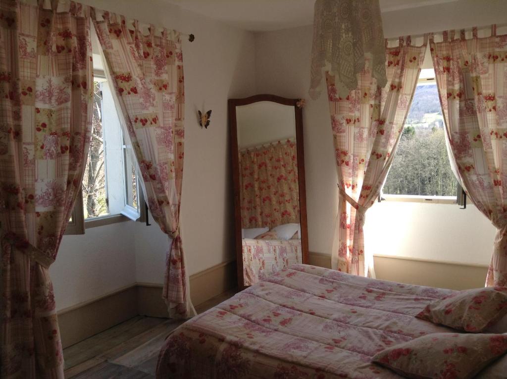 1 dormitorio con cama, espejo y ventanas en Chateau De Benac, en Bénac