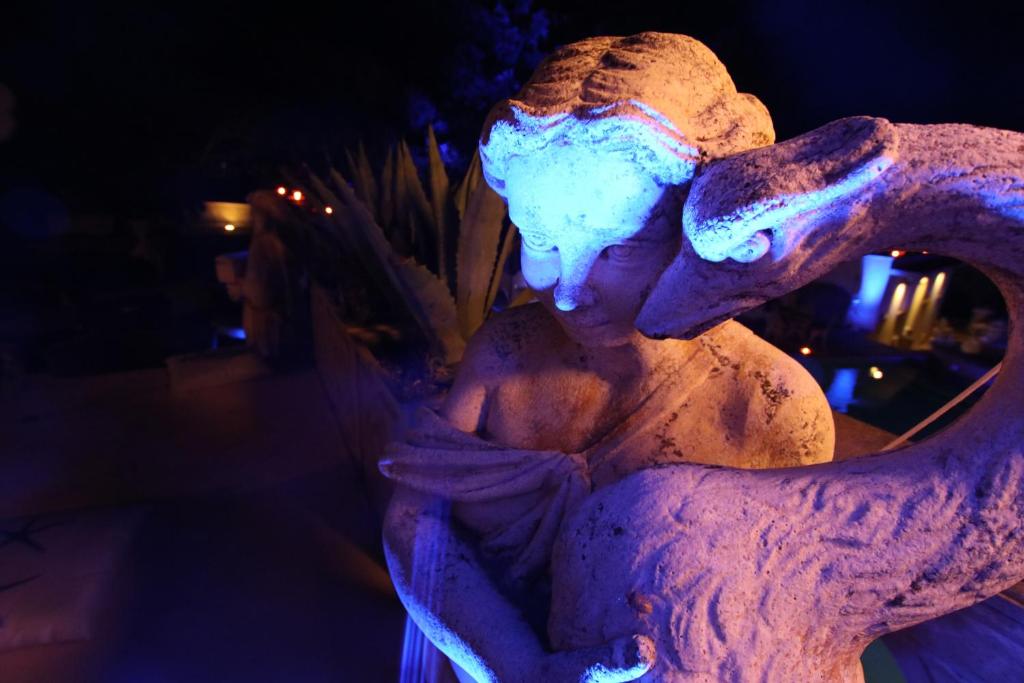 a statue of a woman is lit up in blue lights at Hotel Villa Margherita in Quercianella