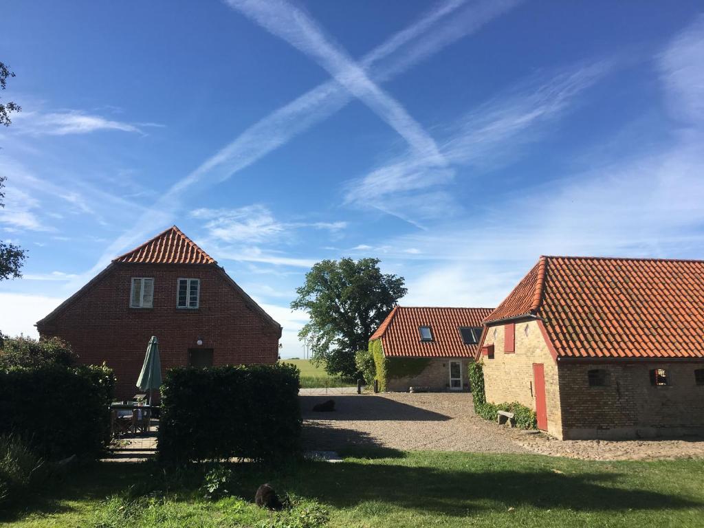 deux bâtiments avec des toits rouges et un ciel bleu dans l'établissement Agerdal Bed & Breakfast, à Nykøbing Mors