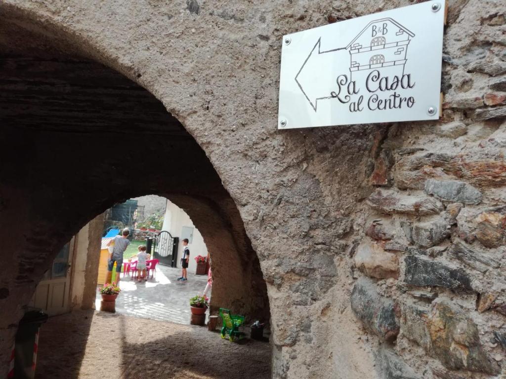 a sign for a restaurant on a stone wall at La Casa al Centro Affittacamere in Levico Terme