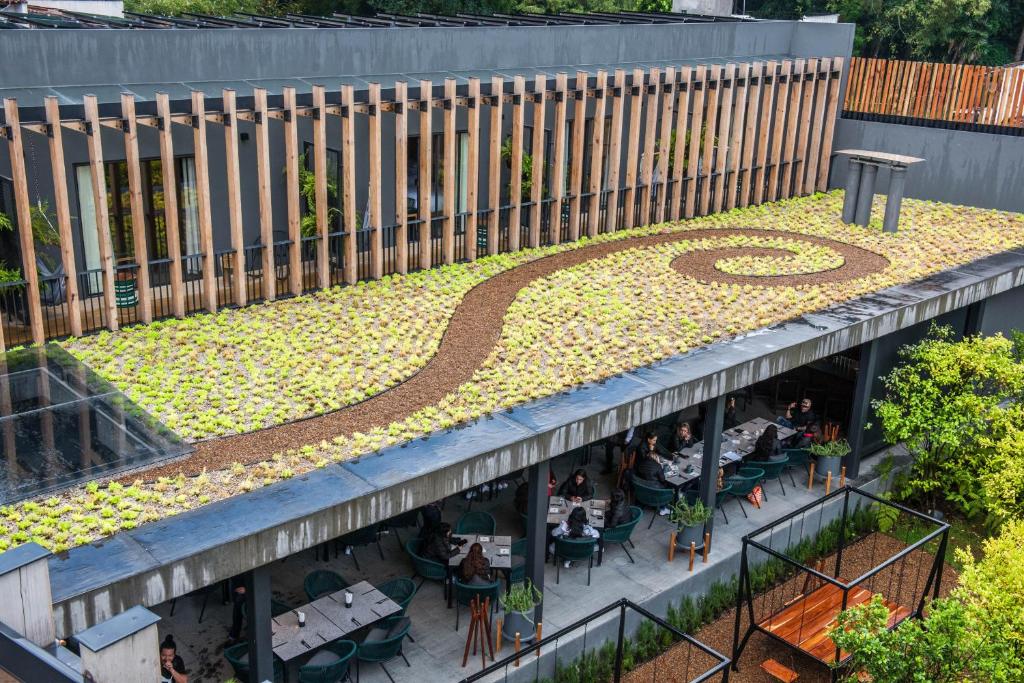 um jardim no telhado de um edifício com pessoas sentadas às mesas em Cinco Rodavento em Valle de Bravo
