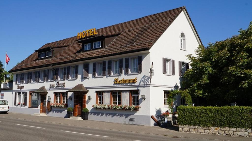 a white building on the side of a street at Hotel Restaurant Kreuz in Kaiserstuhl