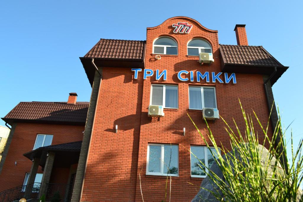 a red brick building with a sign on it at Три Сімки in Vyshhorod