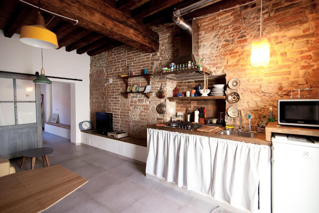 a kitchen with a counter and a brick wall at A casa tua - Apartment in Florence in Scandicci