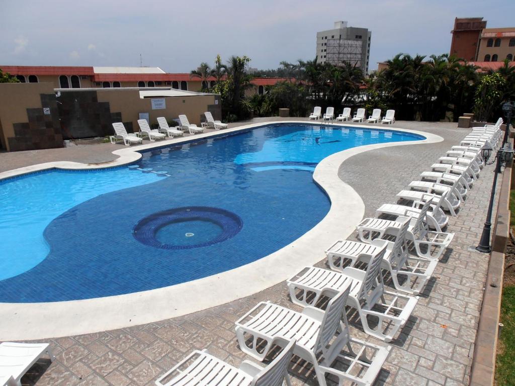 ベラクルスにあるHotel Villas Dali Veracruzの大きなスイミングプール(ラウンジチェア付)、