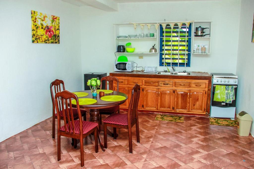 a kitchen with a table and chairs and a sink at Sunshine Lodge: Your home away from home in Montego Bay