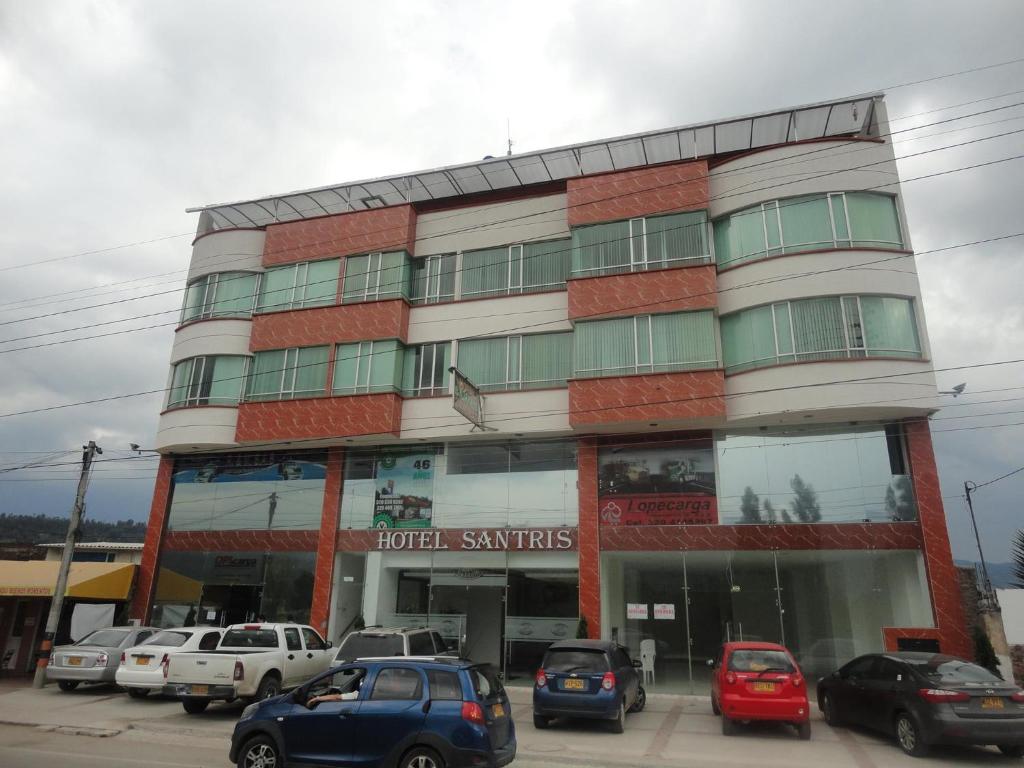 un edificio con coches estacionados frente a él en Hotel Santris, en Duitama