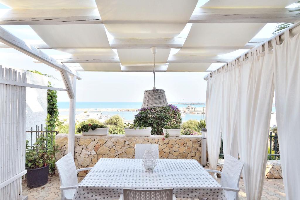ポッツァッロにあるCasa Mare Holiday Pozzalloの海の景色を望むパティオ(テーブル、椅子付)