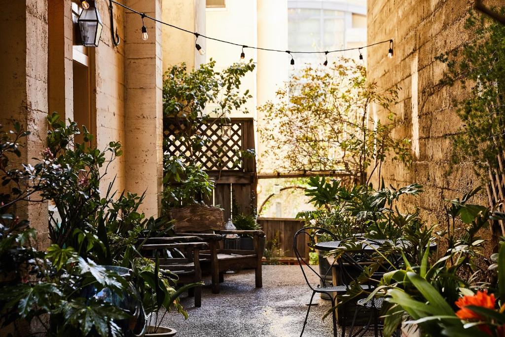 un patio al aire libre con mesas, sillas y plantas en Petite Auberge, en San Francisco