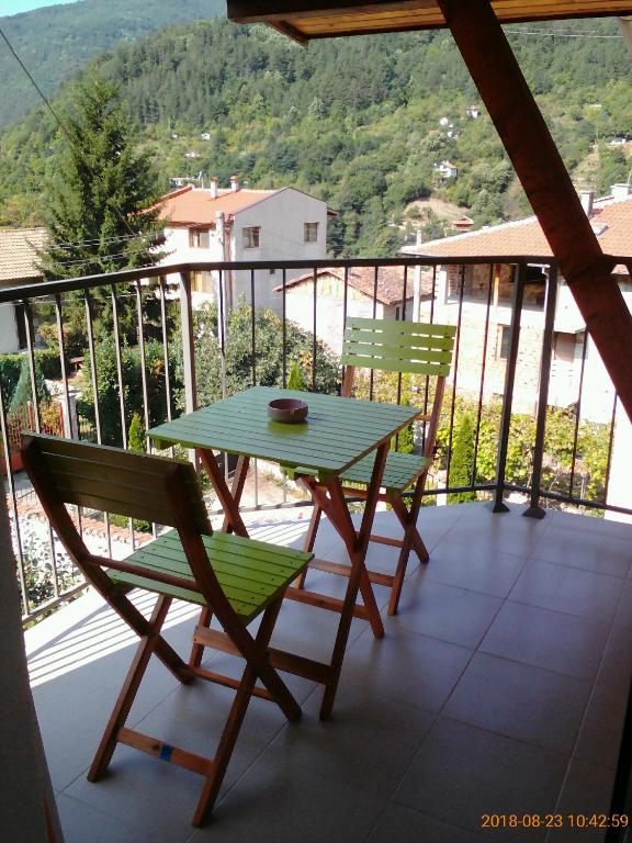 einen grünen Tisch und zwei Stühle auf dem Balkon in der Unterkunft Vila Bachkovo in Batschkowo