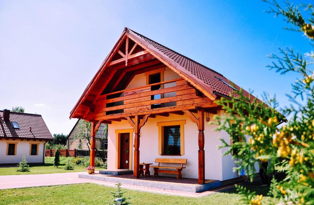 a small house with a wooden roof at Żwirowa Góra - Domki nad Narwią in Tykocin