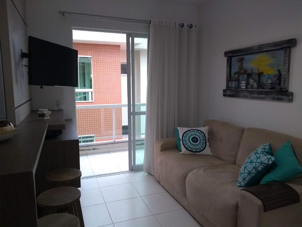 a living room with a couch and a sliding glass door at Apartamento Praia Palmas in Governador Celso Ramos