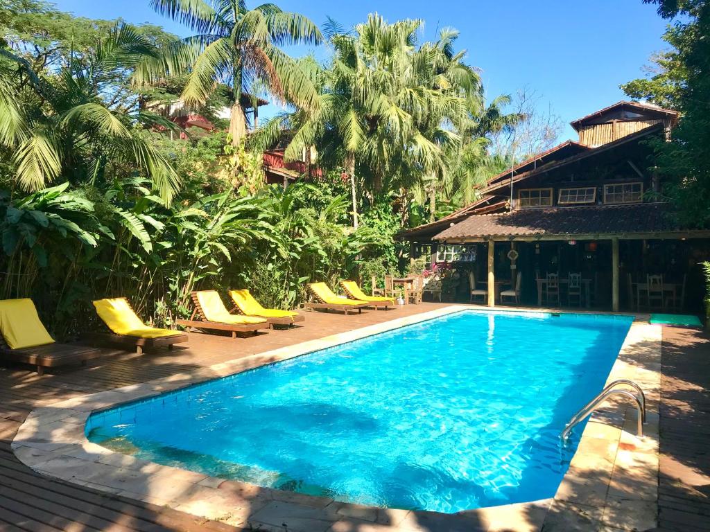 una piscina con sedie a sdraio e un resort di Hotel Pousada Katmandu a Maresias