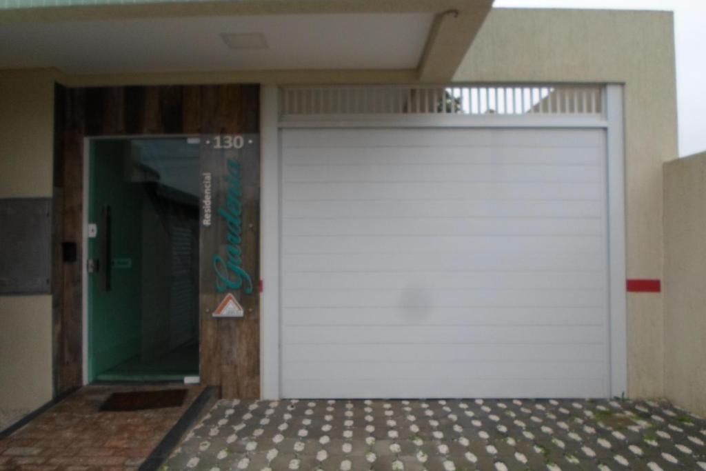 un garaje con una puerta blanca de garaje en un edificio en ALTO PADRÃO - LINDA VISTA MAR, en Bombinhas