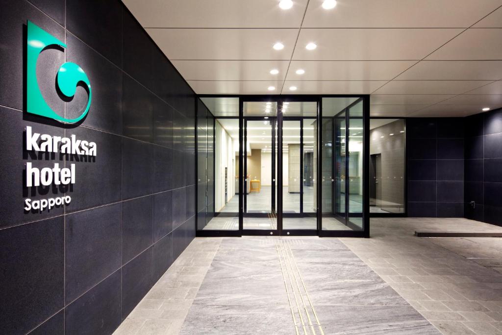 an entrance to an office building with a sign on the wall at karaksa hotel Sapporo in Sapporo