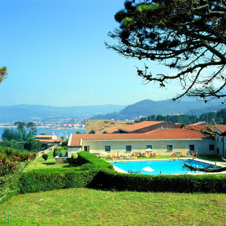 a resort with a swimming pool and a building at Parador de Baiona in Baiona