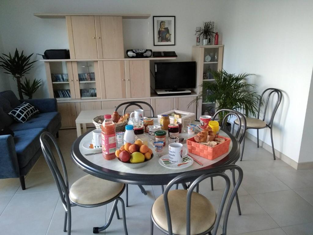 a table with food and drinks and fruit on it at Etape au Calme à 4Km du Center de Reims in Reims