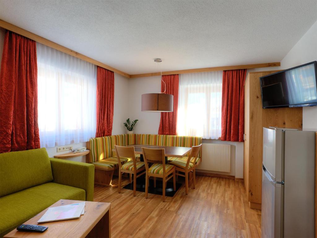 a living room with a green couch and a table at Haus Bickel in Lech am Arlberg